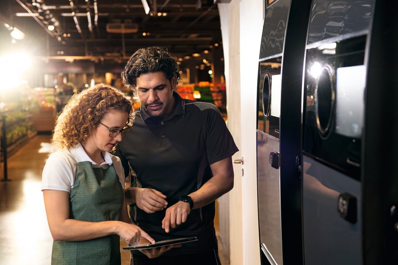 Technician and retailer at a reverse vending machine