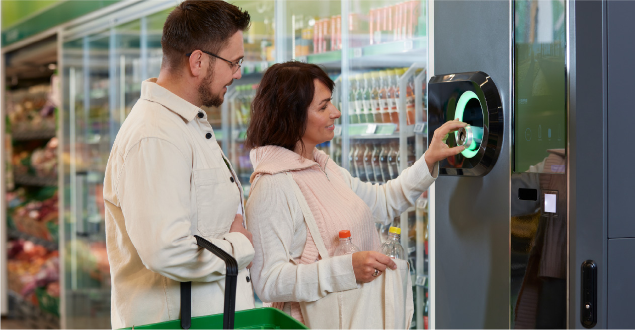 Customer feeding a bottle into a TOMRA machine